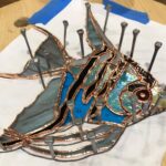 the glass pieces are all copper-foiled and are tacked into place all around with horseshoe nails in preparation for soldering