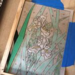 the sketch of the design is taped down and cut pieces of glass have started being laid over their respective shapes in the sketch