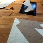 the template pieces are being glued onto their respective colors of glass