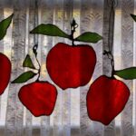 apples of different sizes, shapes and with different amounts of leaves all hung together as a group
