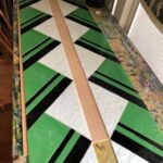 the green, dark brown stripes, and splotchy cream background pieces are all laid in place in preparation for came