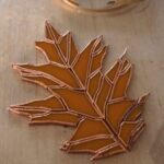all pieces of the oak leaf design have been copper-foiled and laid out in their places