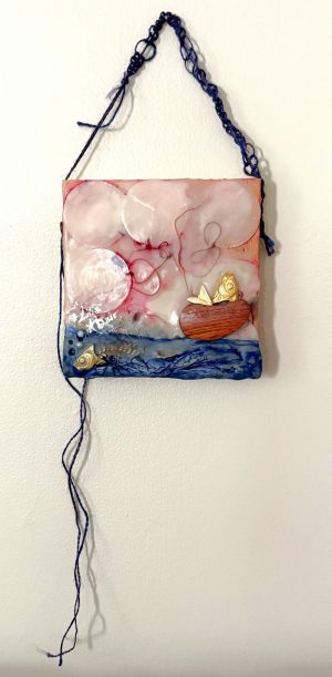 a square mixed media image of two fish, one in the water, one in a wooden boat; there are round clouds in the sky with red edges at the center where a thread swirls above the water and up into a figural shape in the boat